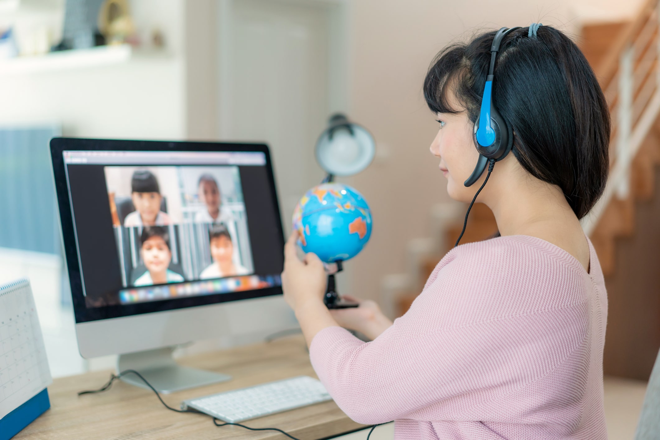 Asian female teaching geography through Zoom